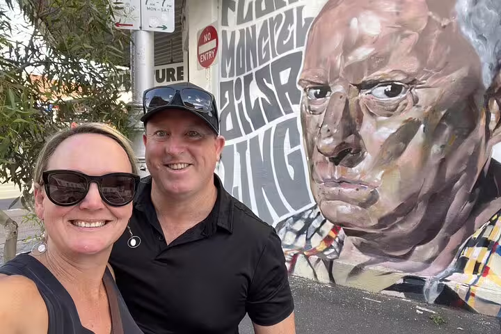 Couple taking selfie in front of large street art mural during Melbourne laneways walking tour