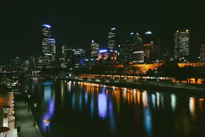 Melbourne city skyline at night reflecting colorful lights on the Yarra River