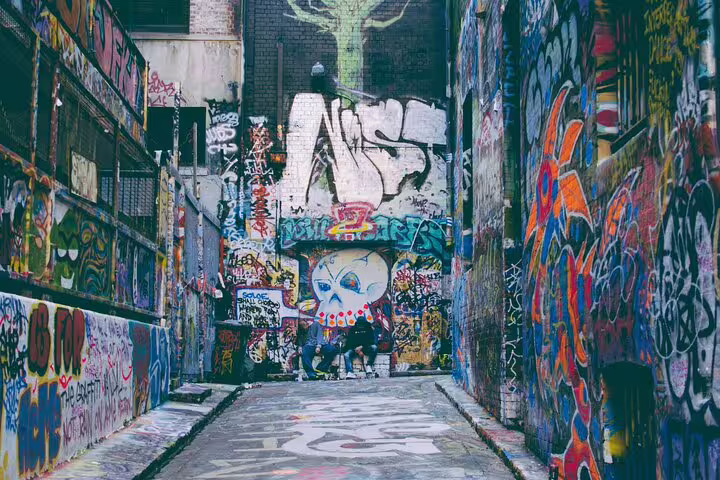 Colorful graffiti-covered alleyway in Melbourne with vibrant street art murals on both walls