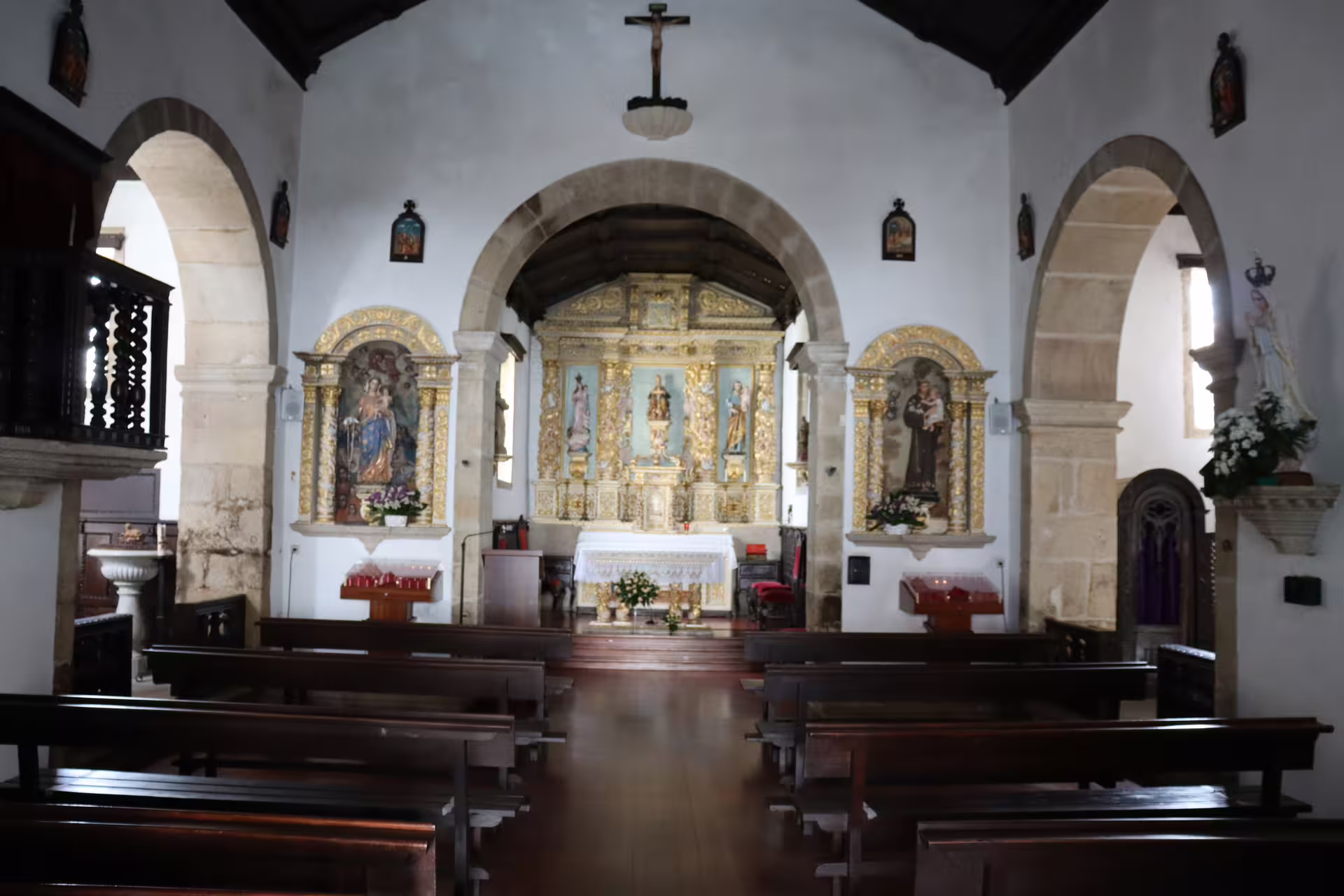 Interior view of a historic church in Melgaço, showcasing ornate altarpieces and arches on a private Alvarinho wine tour.