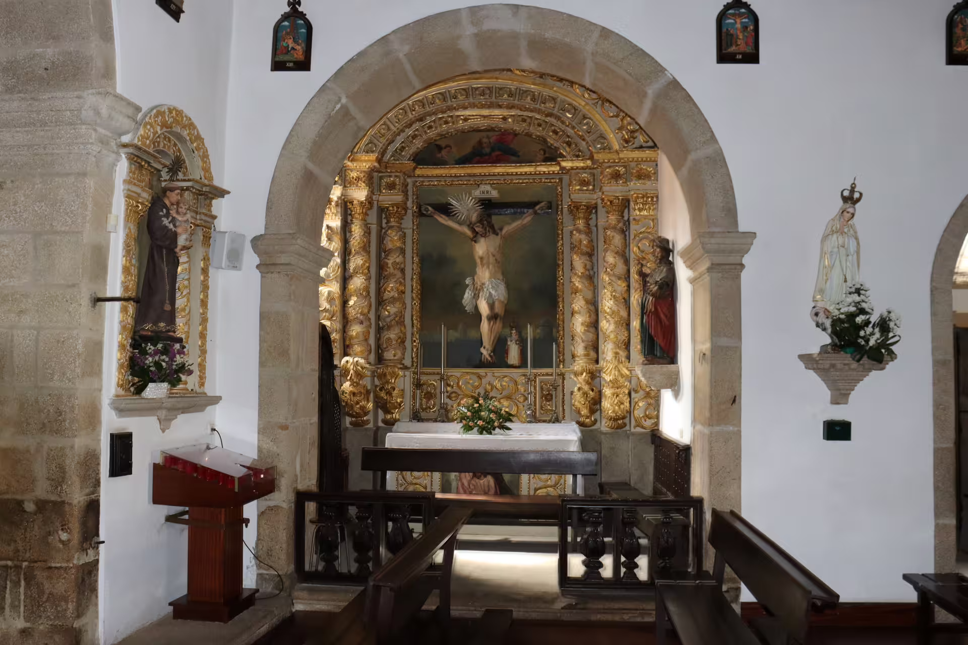 Historic chapel interior in Melgaço and Monção tour, featuring ornate altar and religious statues, heart of Alvarinho region.