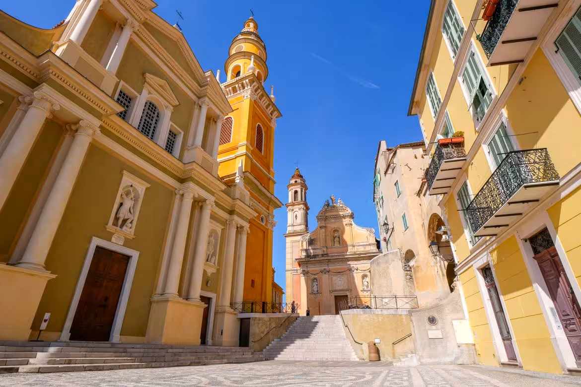Colorful Baroque churches and bell towers in Menton old town square, French Riviera