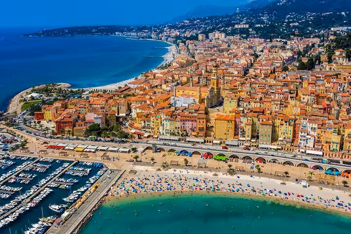 Aerial view of Menton's colorful coastline and marina, highlighting the beauty of the French Riviera tour.