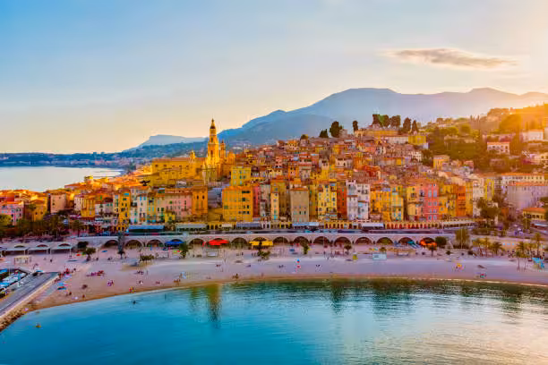 Scenic view of Menton, France, with colorful buildings and sandy beach, perfect for 3 countries in 1 day tour.