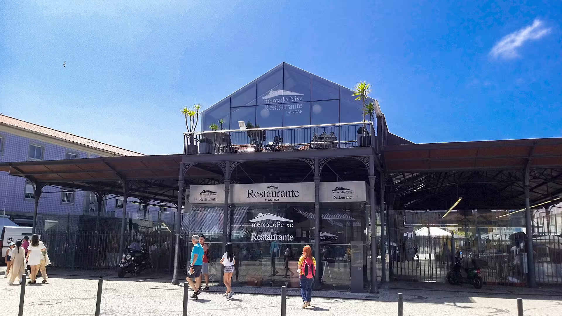 Modern glass-fronted Mercado do Peixe restaurant in Aveiro, Portugal, with visitors exploring the vibrant market area.