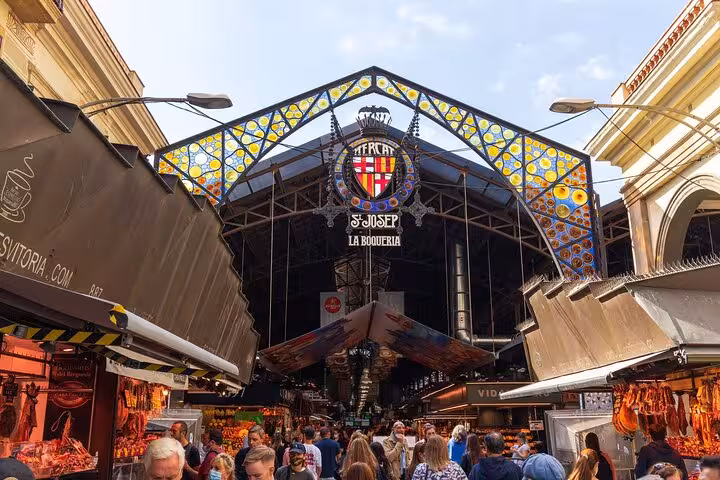 Entrance of Mercat de la Boqueria in Barcelona with crowds, a key stop on local markets food tour