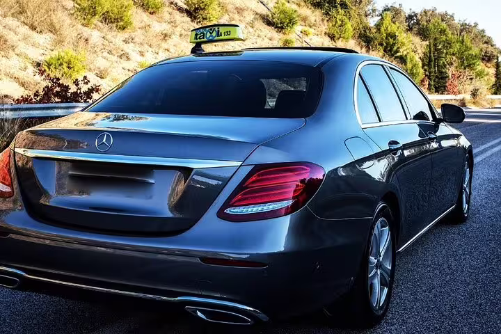 Dark grey Mercedes-Benz sedan taxi on highway road for private transfer service