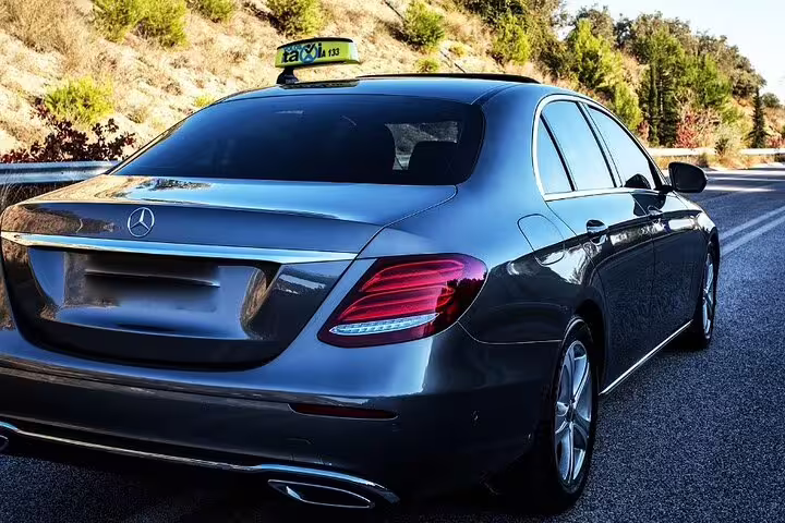 Dark grey Mercedes-Benz sedan taxi on highway for private transfer service