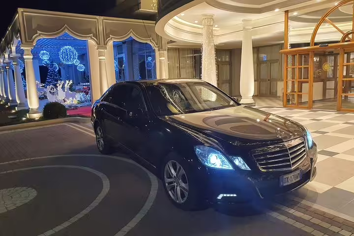 Luxury black Mercedes sedan parked at hotel entrance for private transfer from Valencia Airport VLC to Valencia
