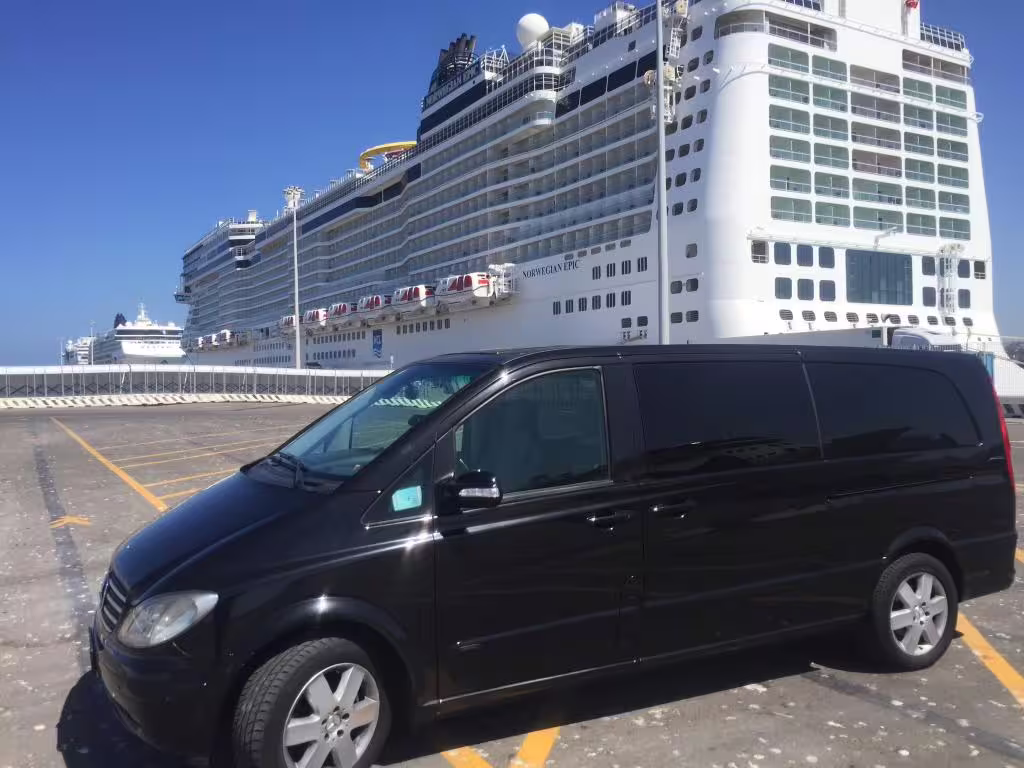 Black Mercedes shuttle van waiting beside a docked cruise ship at Civitavecchia Port for shared transfer to Fiumicino Airport