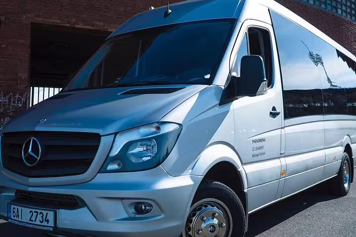 Silver Mercedes-Benz Sprinter premium transfer van parked near brick building