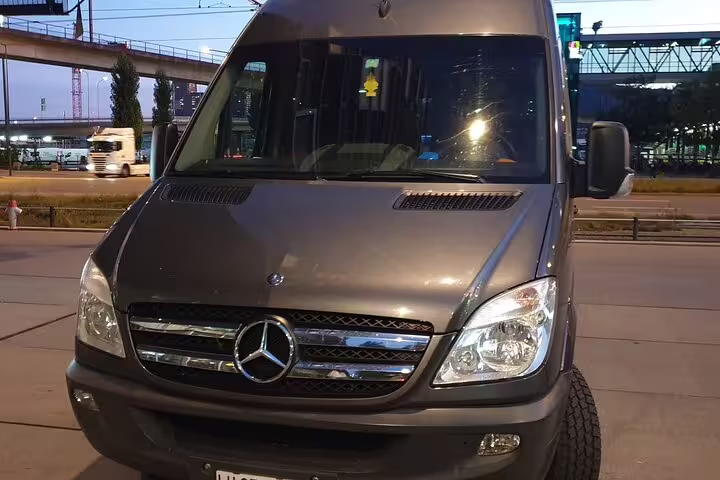 Gray Mercedes-Benz Sprinter van for private transfer service parked at night in urban setting