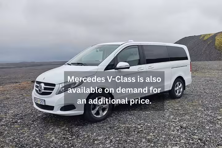 White Mercedes V-Class minivan parked on Iceland's volcanic black gravel landscape under overcast skies