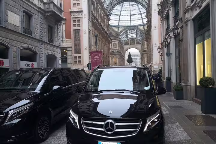 Two black Mercedes V-Class luxury vans parked in city center for private Malaga to AGP Airport transfer service