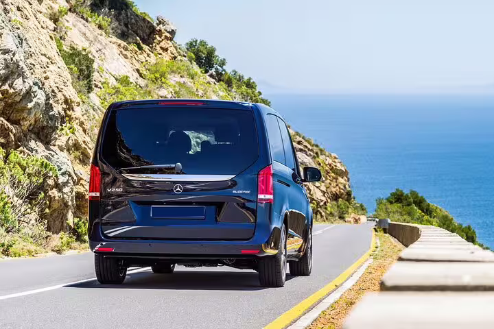 Dark blue Mercedes-Benz V250 BlueTec van driving on a coastal road with blue sea views