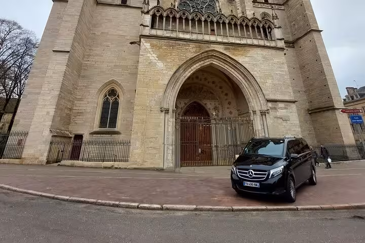 Black Mercedes V-Class van parked in front of a Gothic cathedral in Dijon, France