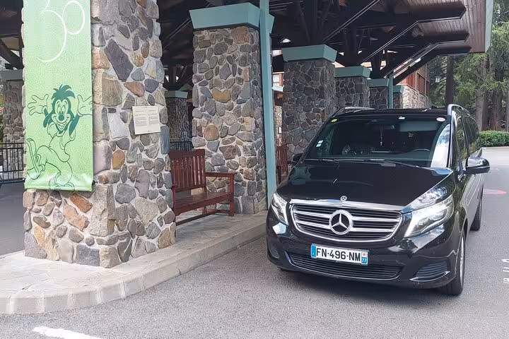 Black Mercedes van parked at Disneyland Paris entrance for private airport transfer