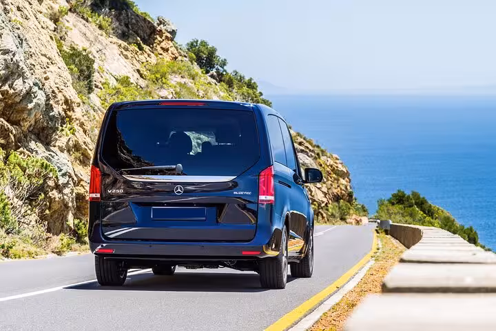 Dark blue Mercedes V250 BlueTec van driving on a coastal road with ocean views in Marseille
