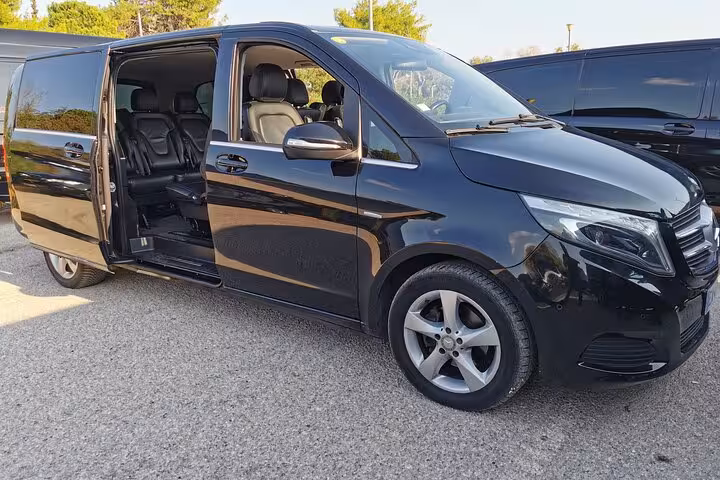 Black Mercedes-Benz V-Class luxury minivan with open sliding door for private airport transfers on French Riviera