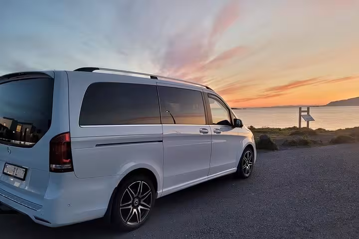 White Mercedes-Benz V-Class minivan parked by the sea at sunset in Iceland