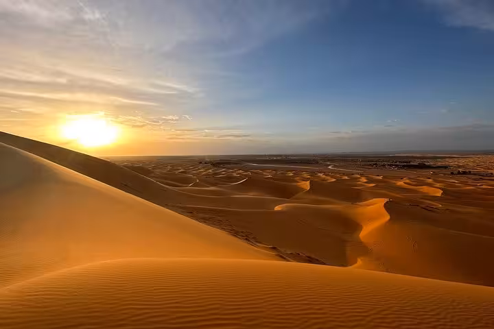 Golden Merzouga dunes at sunrise, highlighting the serene beauty of Morocco's desert landscape.