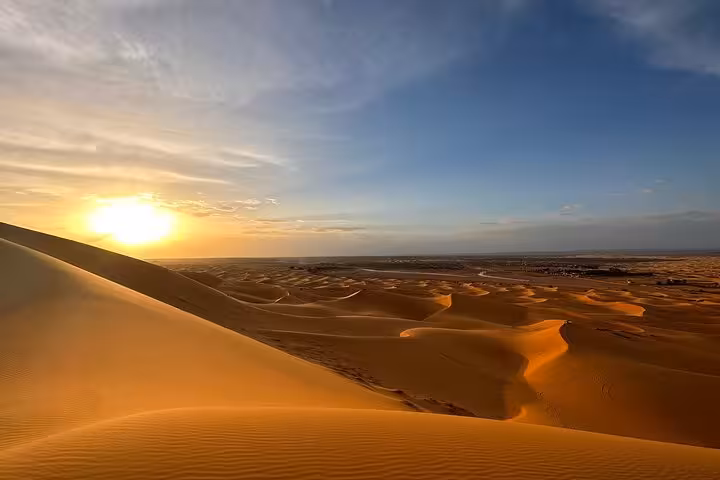 Breathtaking sunset over golden sand dunes in Merzouga Erg Chebbi on a luxury tour from Errachidia to Fes.