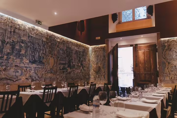 Elegant dining room at Mesa de Frades in Lisbon, featuring intricate azulejo tiles and a cozy ambiance.