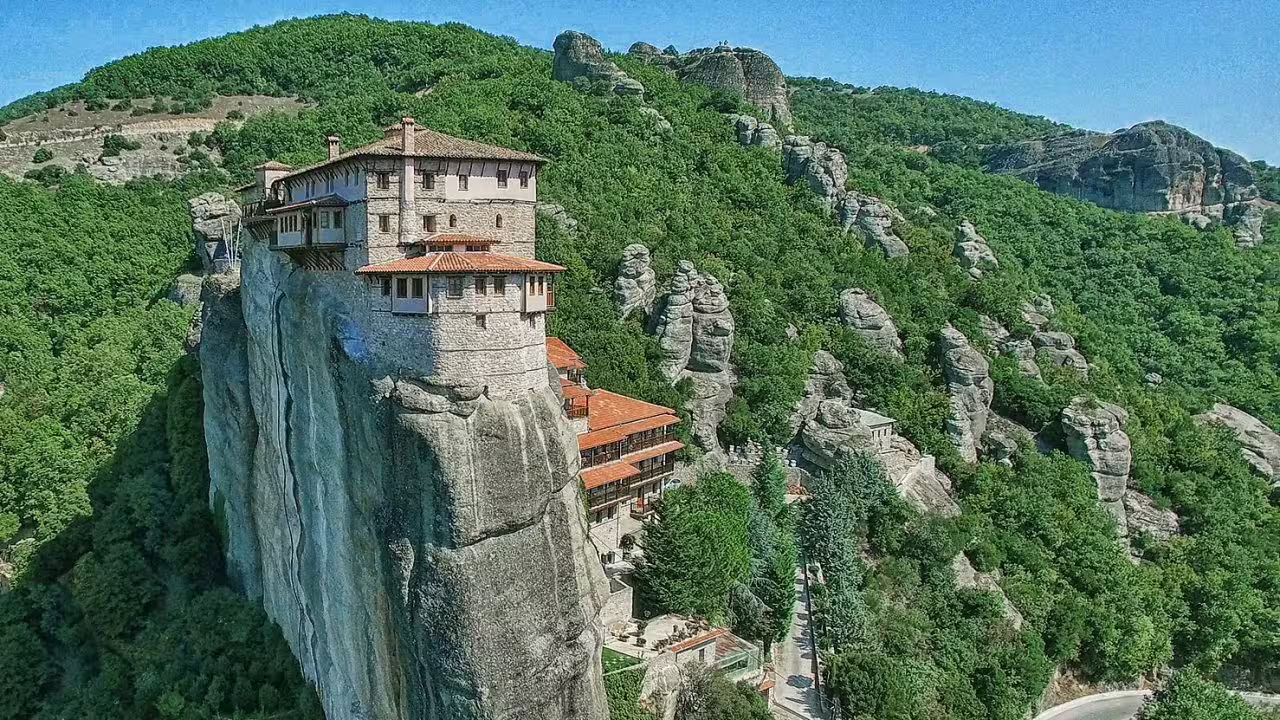 Aerial view of Meteora monastery perched on towering rock, highlight of 2-day private tour from Athens