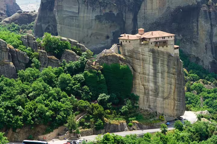 Meteora cliff-top monastery above lush valley, highlight of Delphi and Meteora 2 days private tour Athens