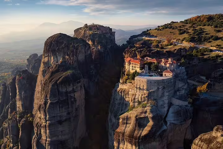 Meteora monastery perched on towering cliffs at sunset, iconic stop on Thermopylae Meteora Delphi private tour