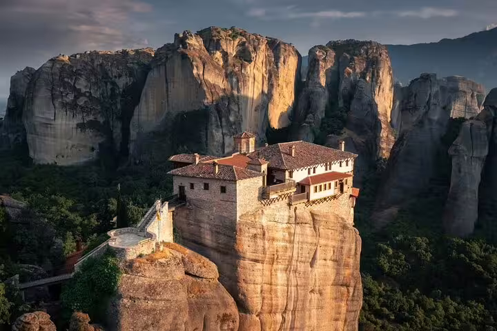 Sunset view of Meteora monastery on dramatic sandstone rocks, must-see on a private Athens to Meteora day tour