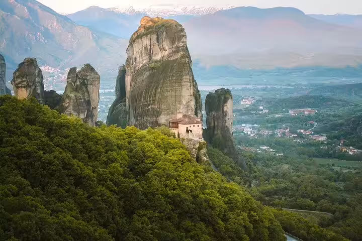 Meteora private day tour from Athens featuring cliffside monastery and towering rock pillars above Thessaly valley