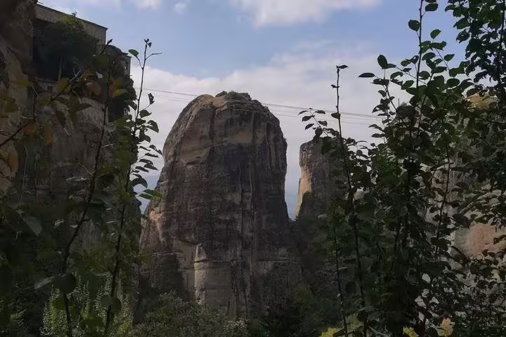 Meteora rock pillars and cliffs framed by greenery on private day trip from Athens to Delphi and Meteora