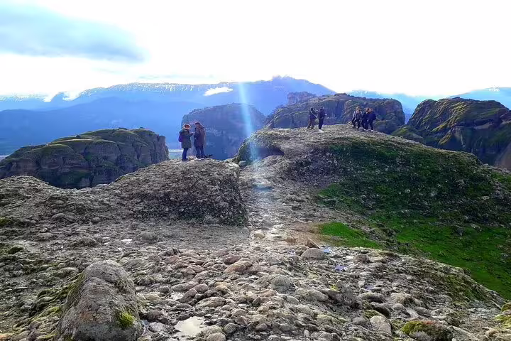 Visitors exploring the rocky landscape of Meteora with panoramic views of the mountainous region.