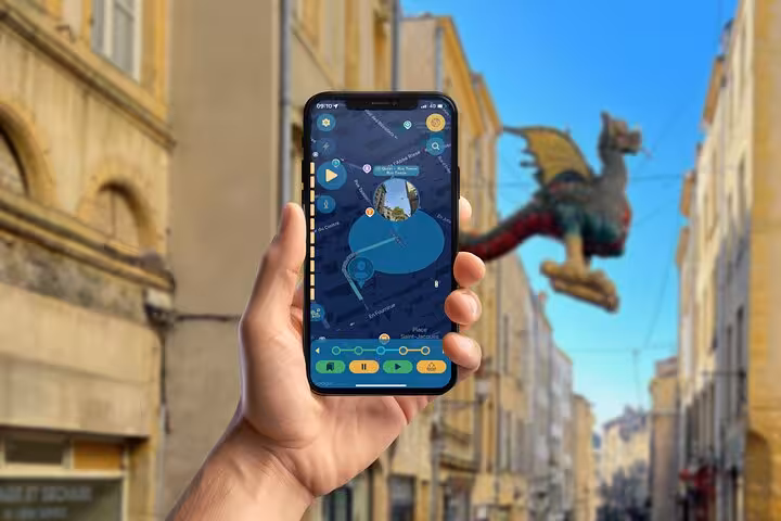 Hand holding smartphone with Metz walking tour app, dragon sculpture visible in city street background