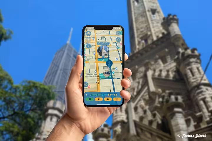 Hand holding phone displaying self-guided Michigan Avenue walking tour app near historic Chicago Water Tower landmark