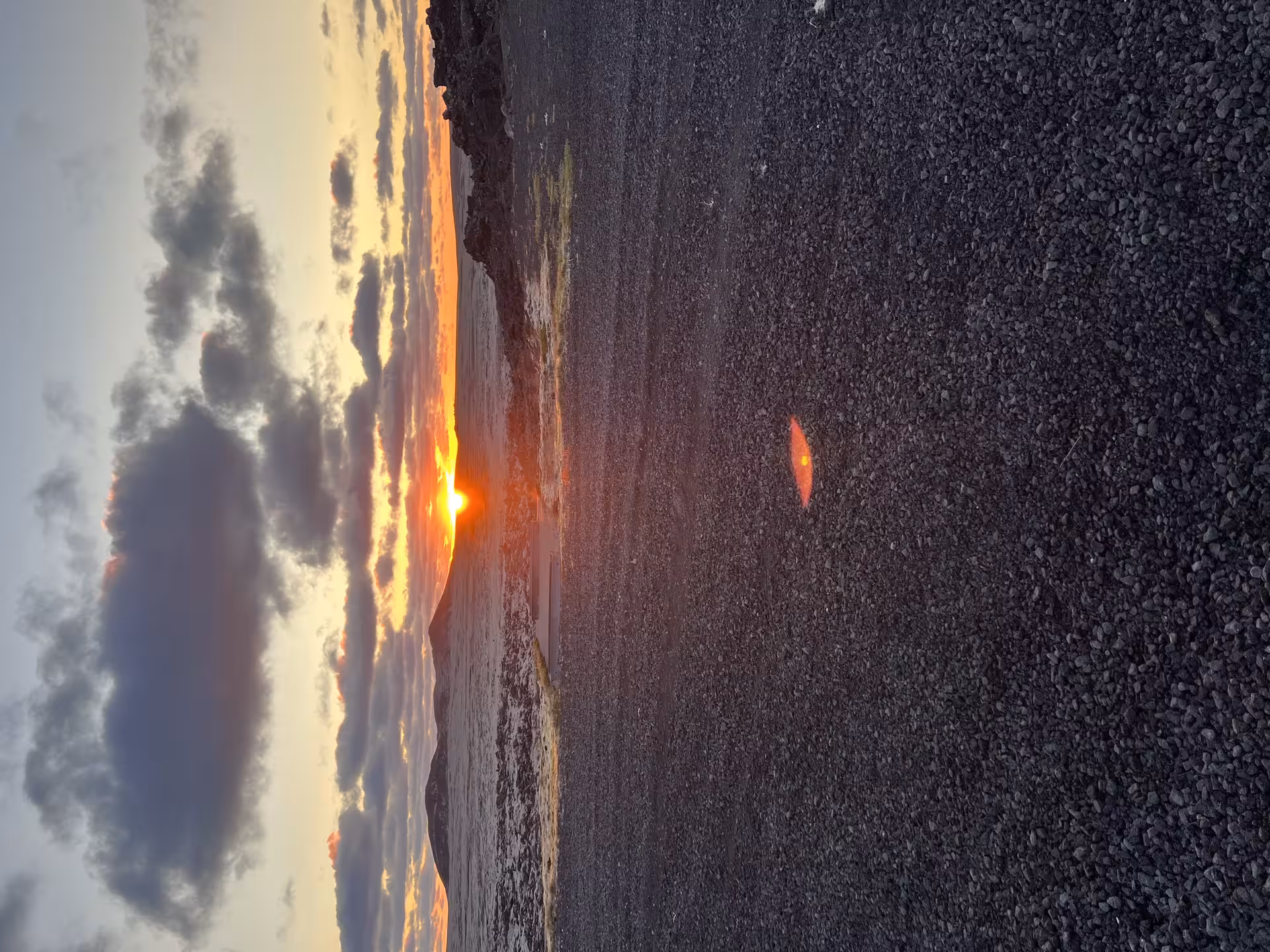 Midnight sun setting over Reykjanes lava fields with dramatic orange and gold sky in Iceland