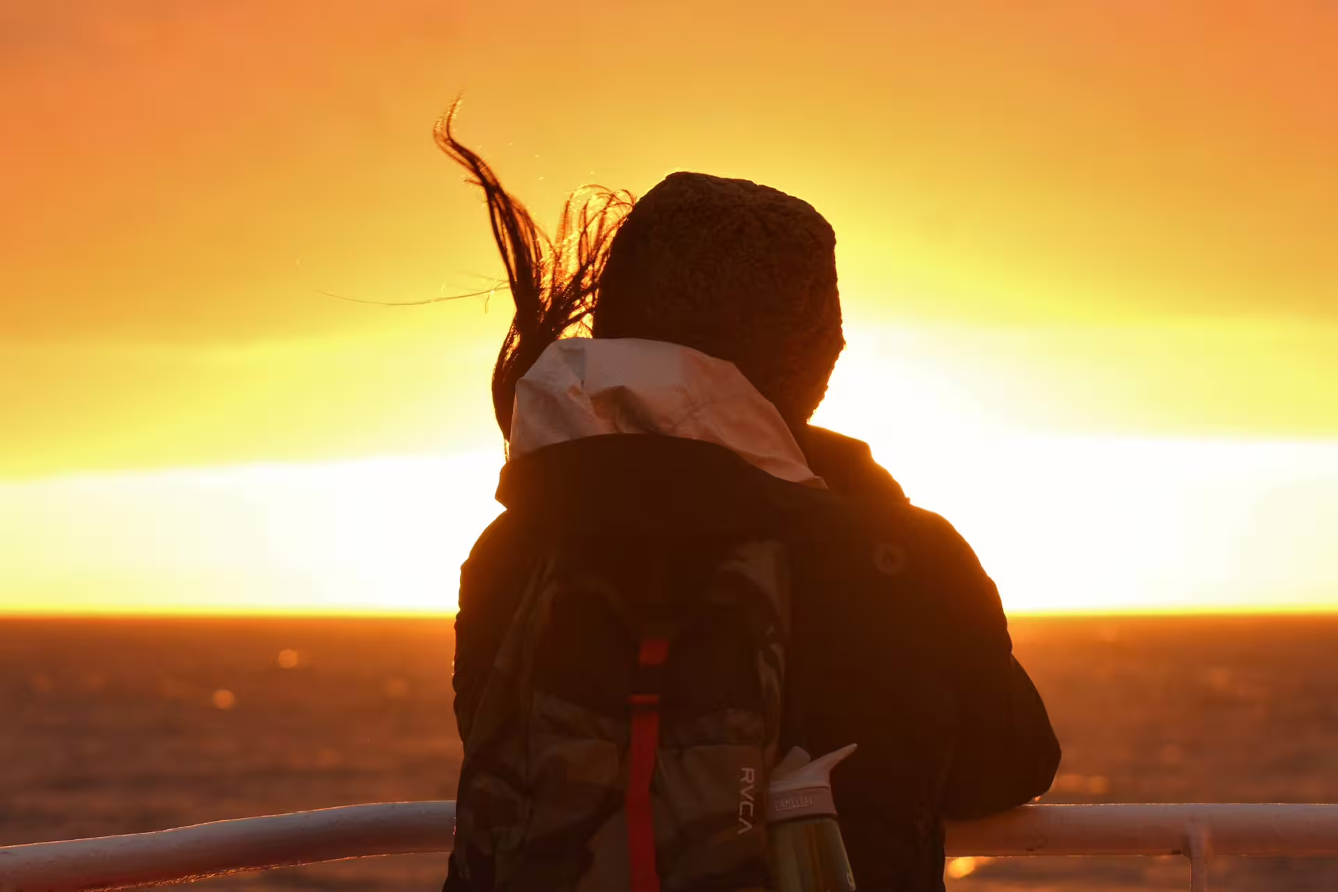 Couple embracing on boat deck watching vibrant midnight sun over Reykjavik waters
