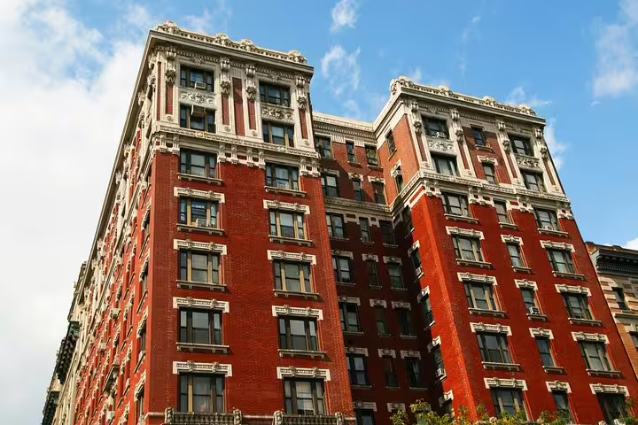 Historic red brick apartment building in Midtown NYC with ornate beaux-arts architectural details