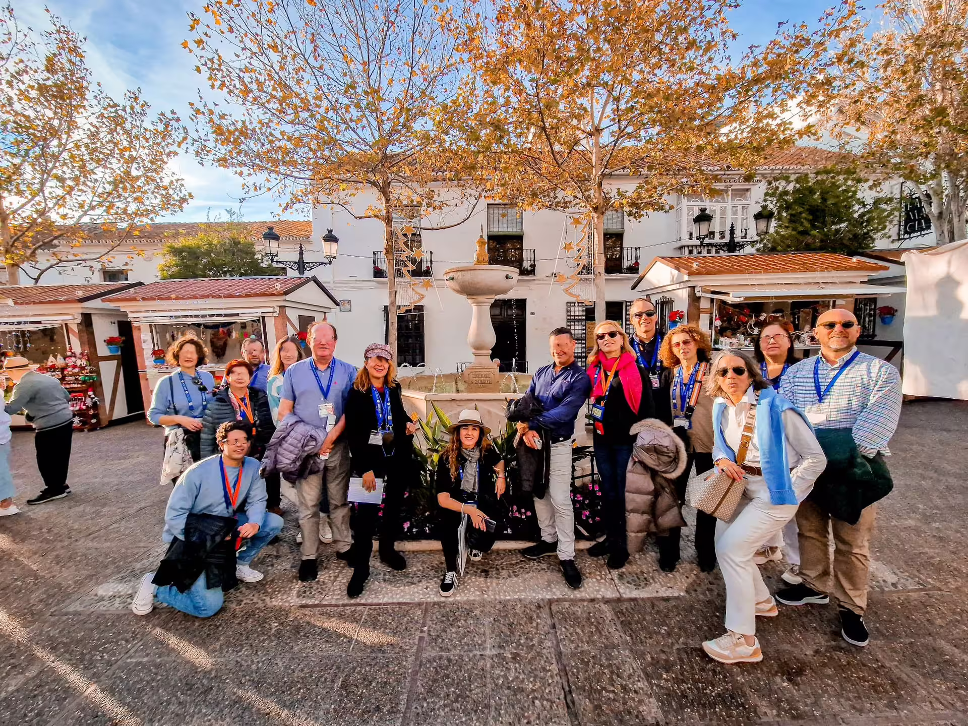 Small group at Mijas Pueblo fountain and market stalls during private full-day Malaga and Mijas trip with pickup