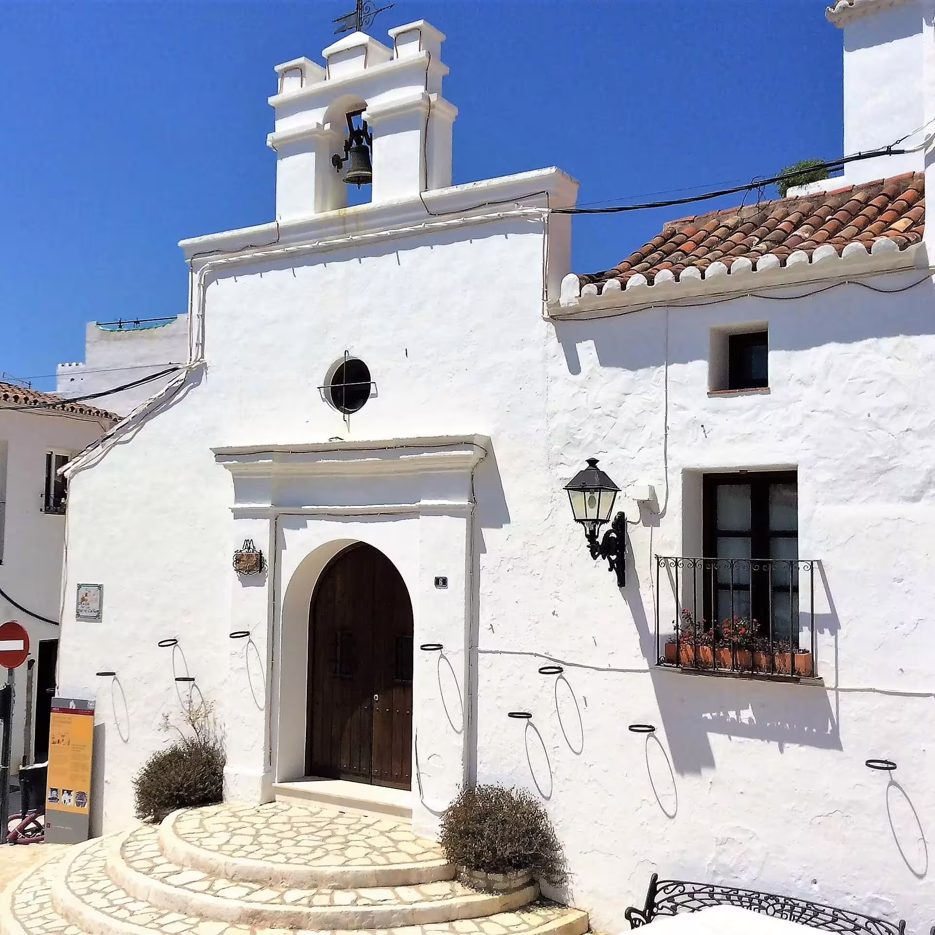 Traditional whitewashed chapel facade with bell tower in Mijas Pueblo, seen on a guided group walking tour