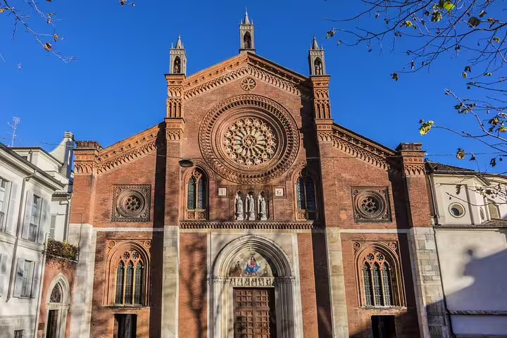 Gothic brick facade of San Marco church in Milan's Brera district with rose window and arched entrance