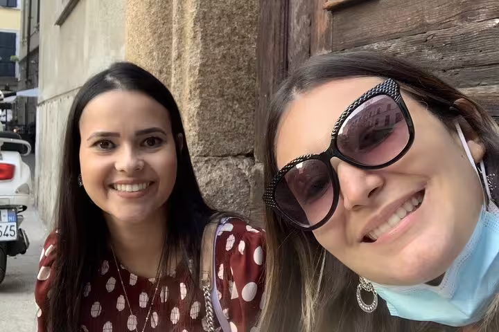 Two smiling women taking a selfie on a Milan street during a self-guided exploration game tour