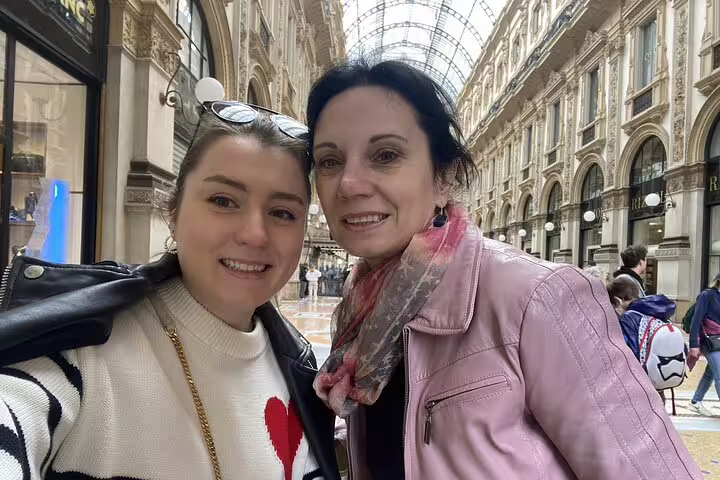 Two women smiling together inside Galleria Vittorio Emanuele II during Milan walking tour
