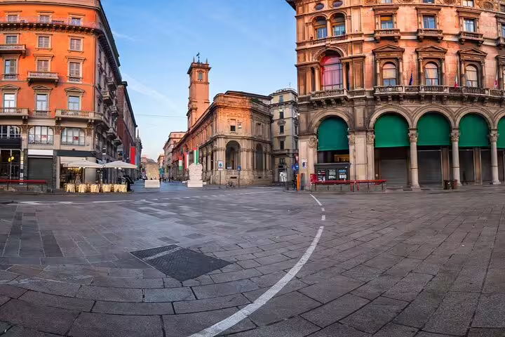 Empty historic piazza in Milan with ornate terracotta buildings and cobblestone square at golden hour
