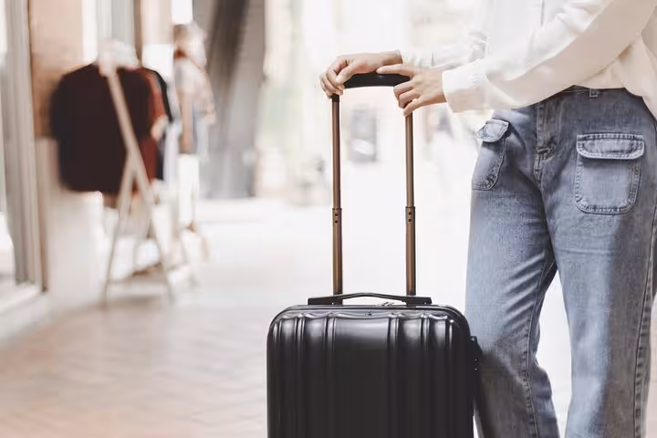 Traveler with rolling suitcase using luggage storage near Milan Centrale, hands-free sightseeing and train connections