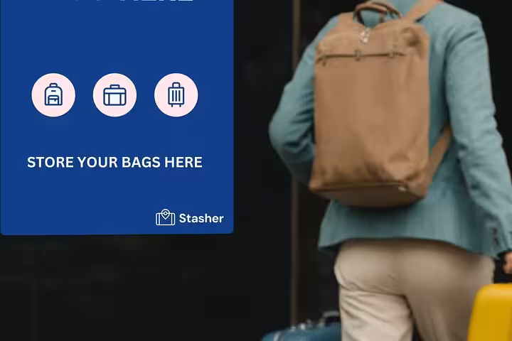 Traveler with backpack and suitcase beside Stasher sign, Milan Central Station luggage storage drop-off point
