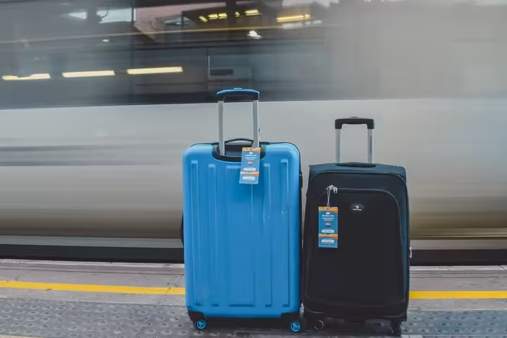 Two suitcases on platform by train, secure luggage storage near Milan Central Station for day trips and layovers