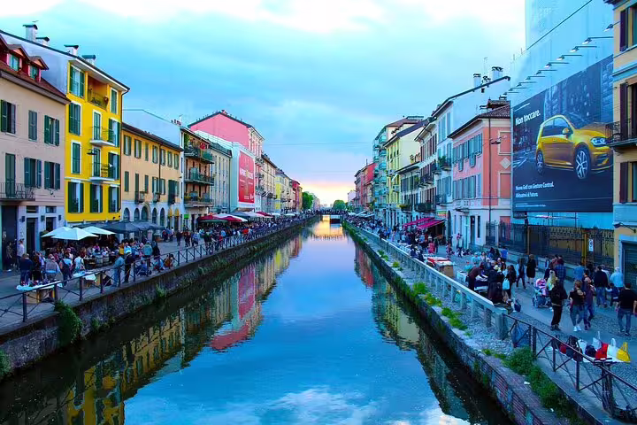 Vibrant canal view in Milan's Navigli district, showcasing colorful buildings and lively atmosphere on a private sightseeing tour.