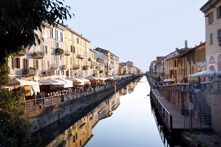 Navigli canal lined with colorful buildings and outdoor restaurant terraces in Milan, Italy